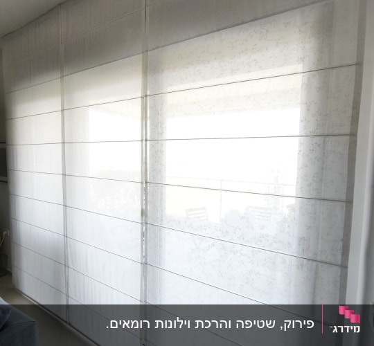 וילונות לבנים תלויים בחדר מואר